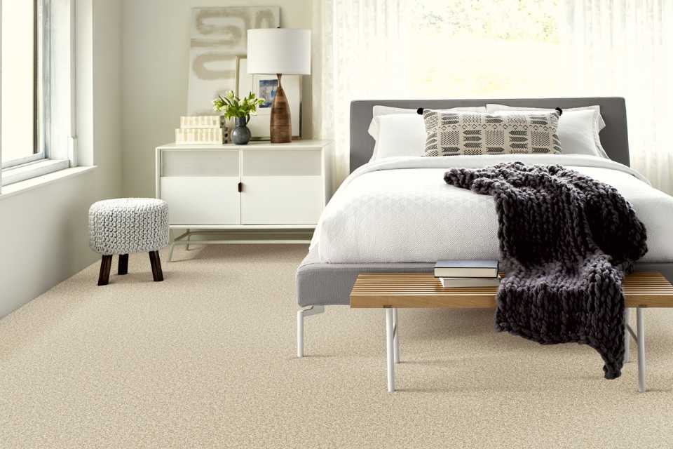 plush beige carpet in bedroom retreat with cozy layers and bedding
